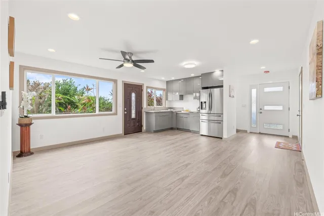 a view of a kitchen with a stove cabinets a ceiling fan and wooden floor