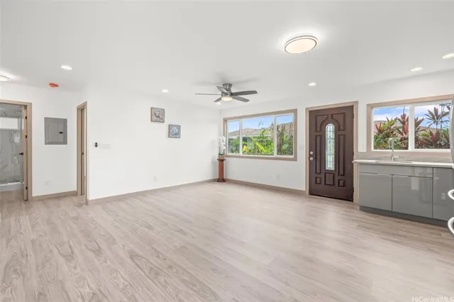 a view of an empty room with a window and wooden floor