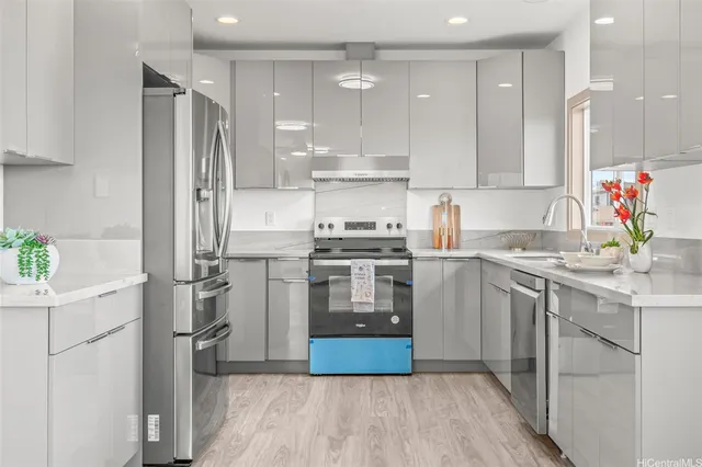 a kitchen with a sink stainless steel appliances and white cabinets