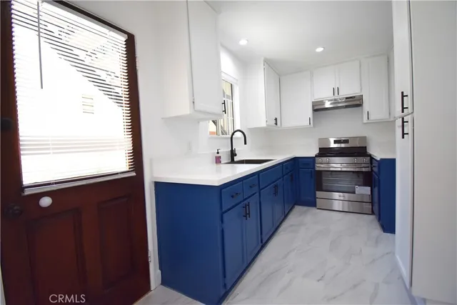 a kitchen with stainless steel appliances a sink stove and cabinets