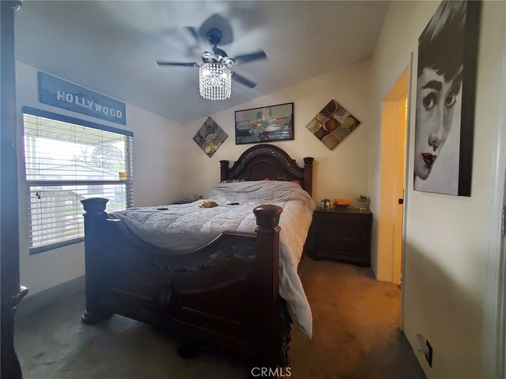 29021 Bouquet Canyon Road, Unit 317 Saugus, CA 91350 - Photo 21 of 24 a bedroom with a bed and a chandelier