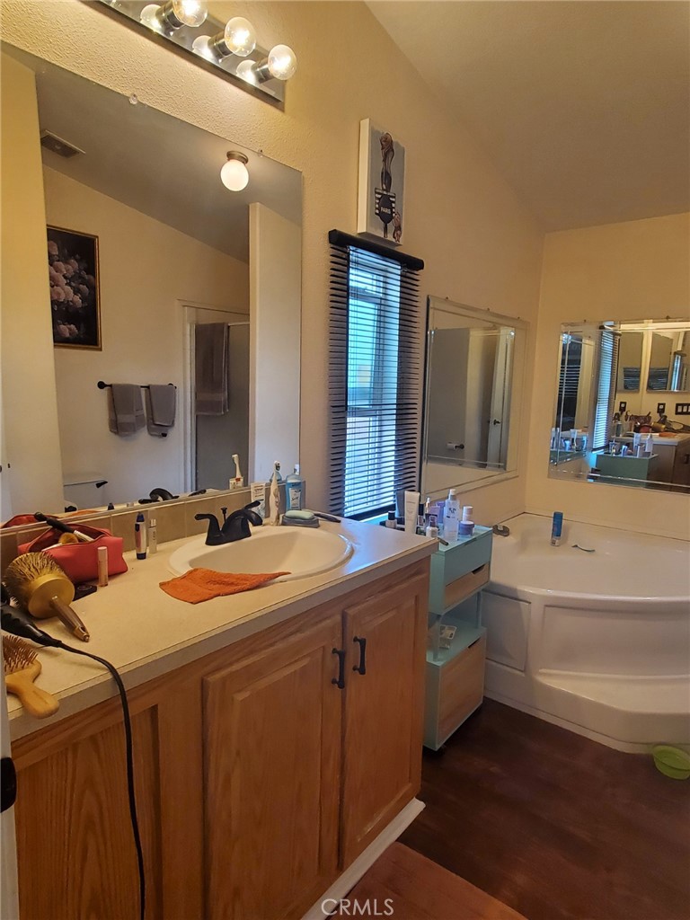 29021 Bouquet Canyon Road, Unit 317 Saugus, CA 91350 - Photo 23 of 24 a bathroom with a tub sink and mirror