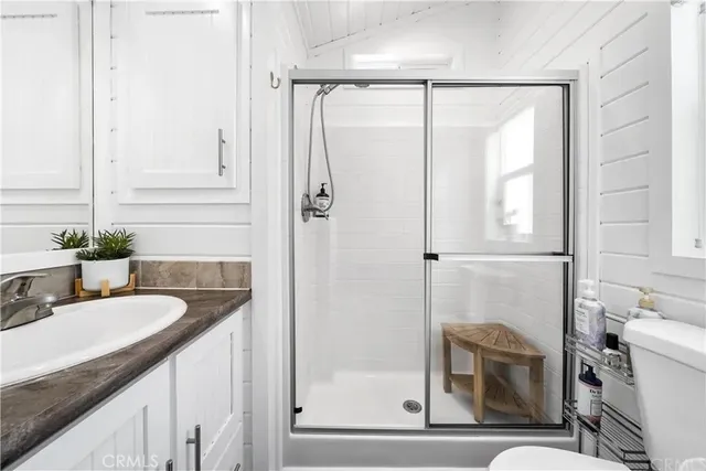 a bathroom with a granite countertop sink mirror and shower