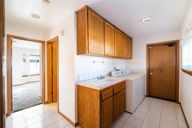 a utility room with a sink and cabinets