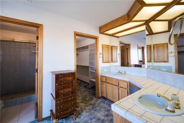 a spacious bathroom with a sink a mirror and a shower