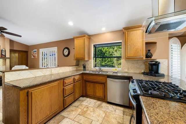 a kitchen with stainless steel appliances granite countertop sink stove and refrigerator