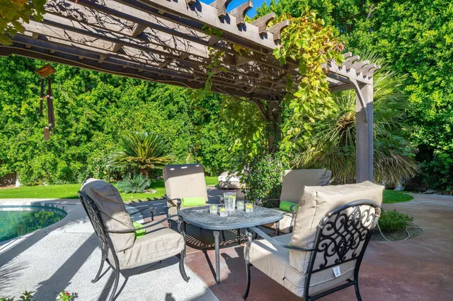 a view of a chairs and table in backyard of the house