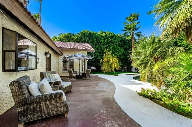 a view of a patio with couches and table and chairs and potted plants