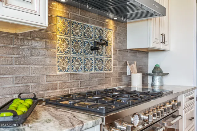 a view of a white house with a yard and table and chairs under an umbrella