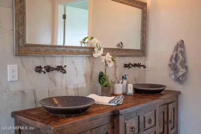 a backyard of a house with table and chairs under an umbrella