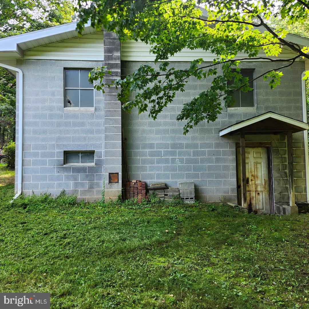 2445 Bear Wallow Hollow Road Augusta, WV 26704 - Photo 16 of 22 a brick house with a small yard and a large tree