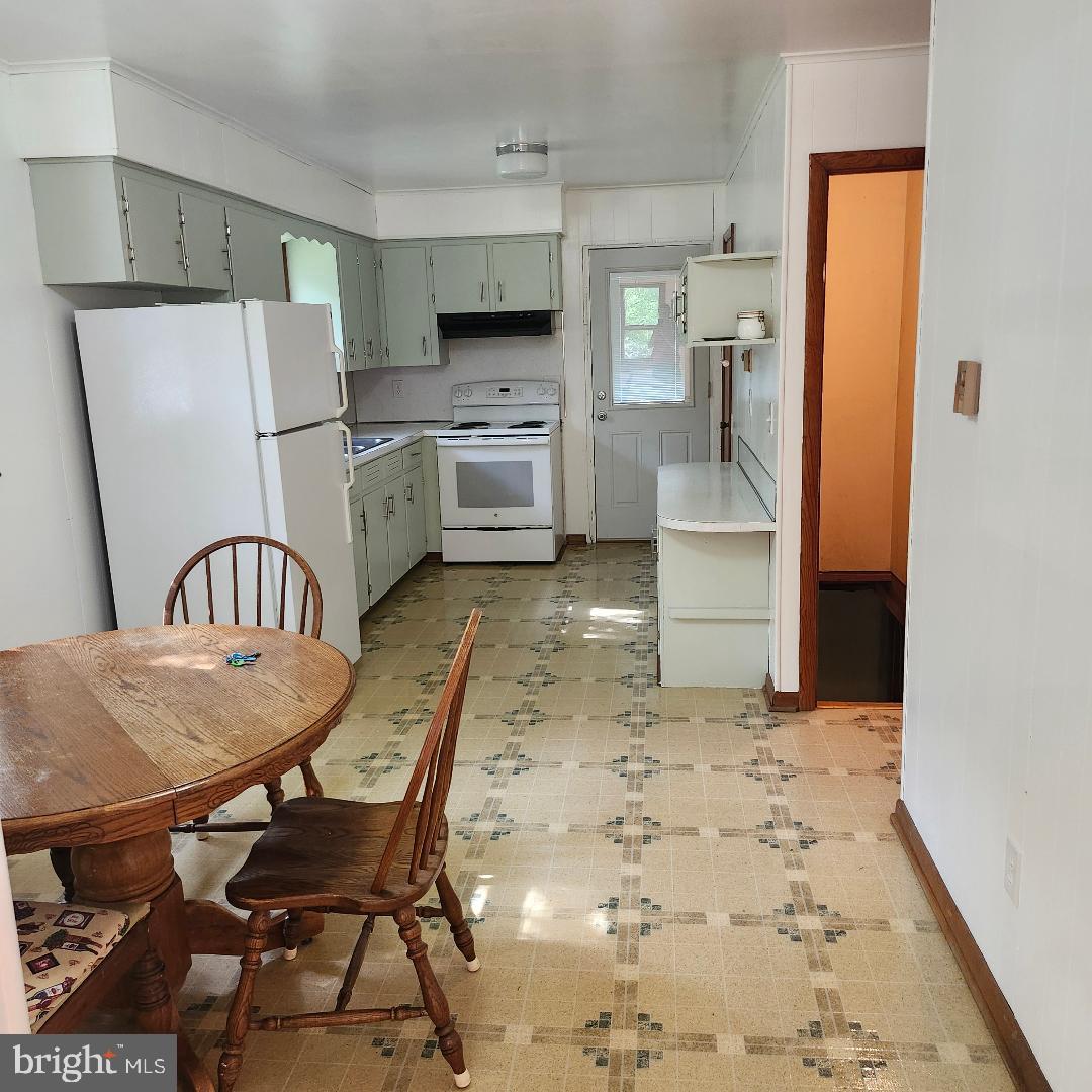 2445 Bear Wallow Hollow Road Augusta, WV 26704 - Photo 6 of 22 a kitchen with stainless steel appliances refrigerator stove microwave and dining table