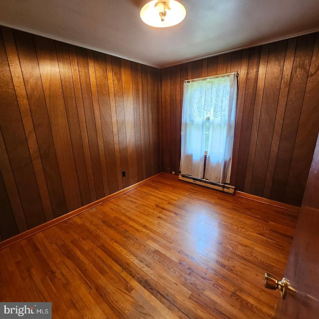 2445 Bear Wallow Hollow Road Augusta, WV 26704 - Photo 10 of 22 an empty room with wooden floor and windows