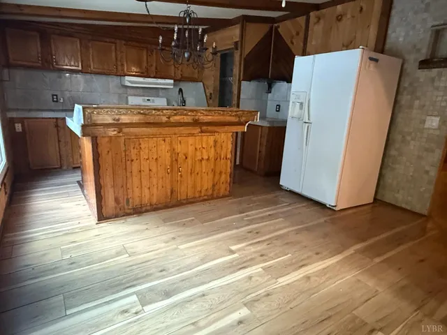 a view of a kitchen with refrigerator and cabinets