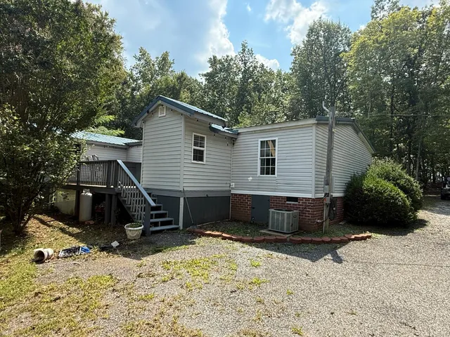 a view of house with backyard and sitting area