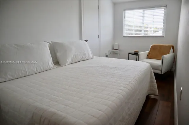 a large bed sitting in a bedroom next to a window