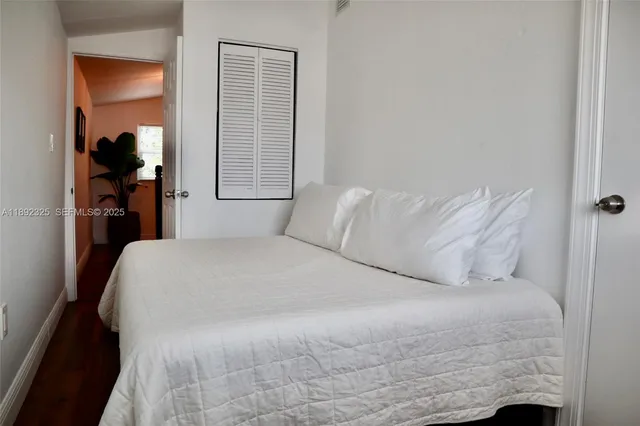 a large bed sitting in a bedroom next to a window
