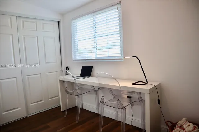 a view of a workspace with furniture and a window