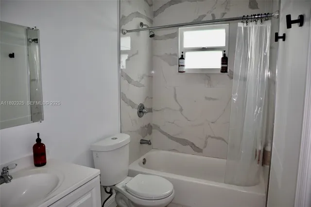 a bathroom with a shower a toilet and a sink