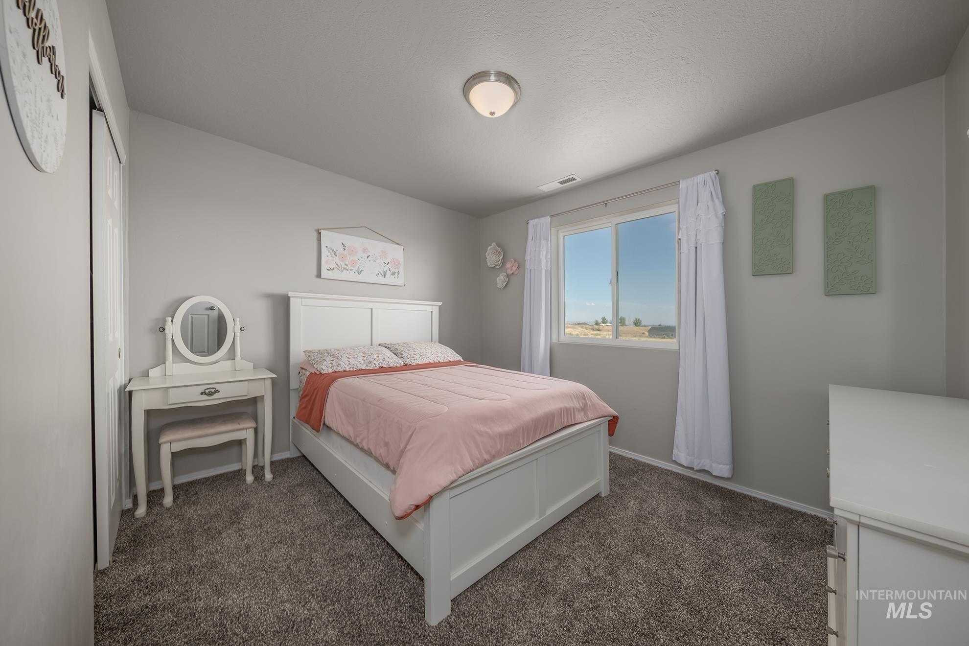 1049 Price Road Weiser, ID 83672 - Photo 24 of 47 Spacious room featuring neutral carpeting, light gray wall paint, and a large window with white trim