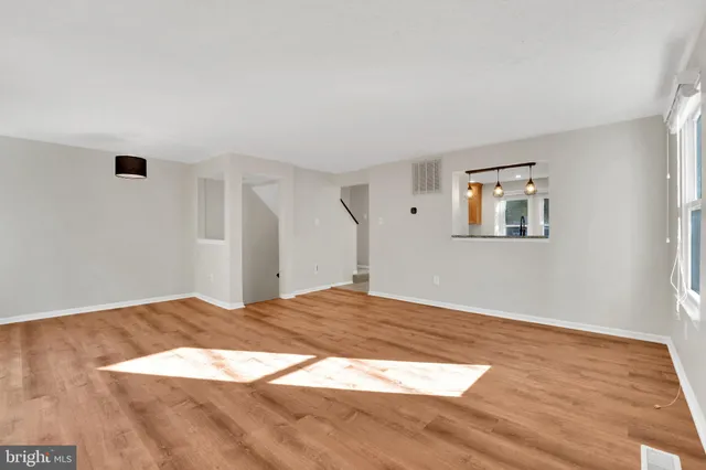 a view of a big room with wooden floor and windows