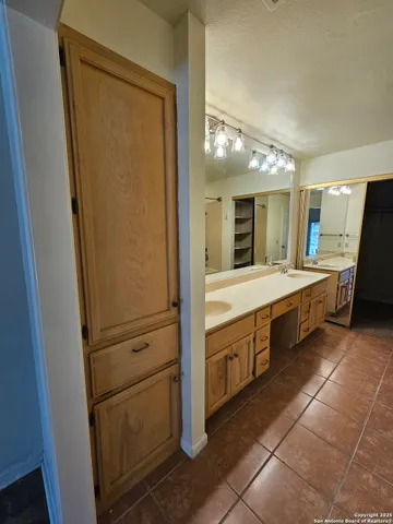 a large bathroom with a double vanity sink and a mirror