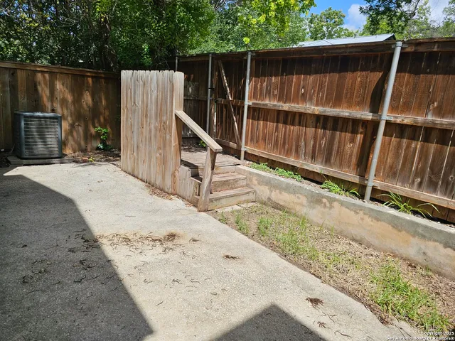 a view of a backyard with wooden fence