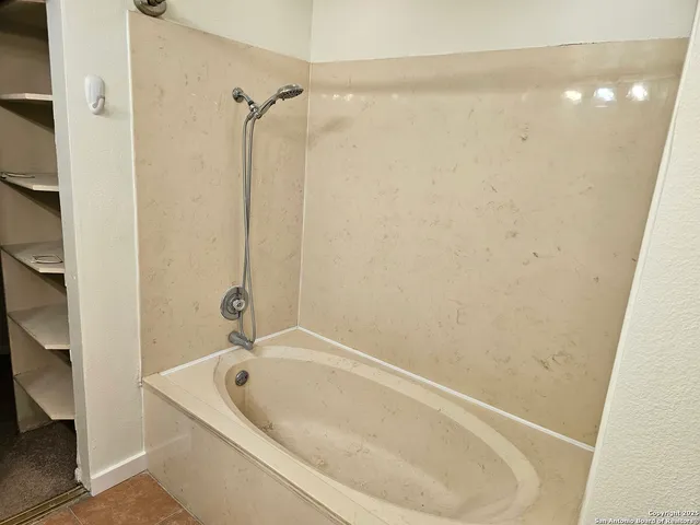 a bathroom with a tub and shower
