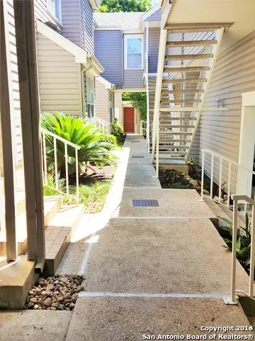a view of a house with a yard and pathway