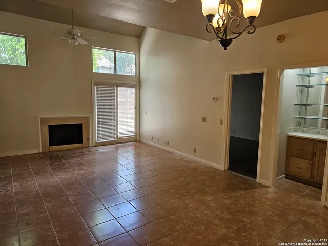 an empty room with windows and fireplace