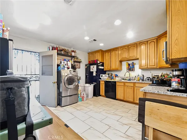 a kitchen with stainless steel appliances granite countertop lots of counter top space a sink a stove a refrigerator cabinets and a window