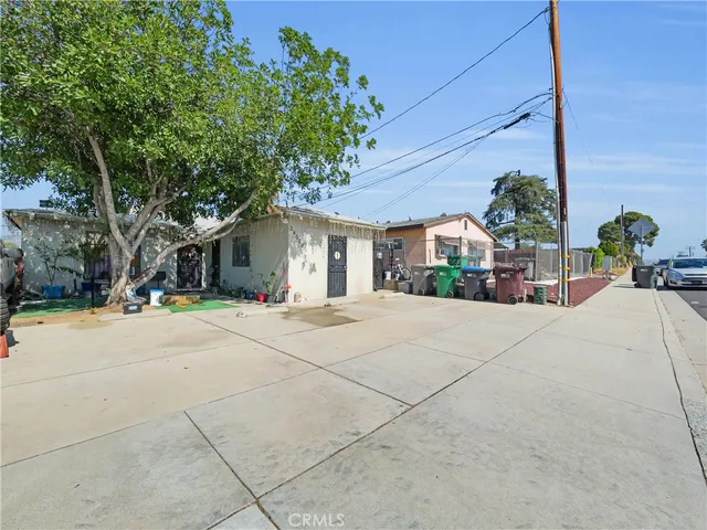 a view of a white house with a large tree