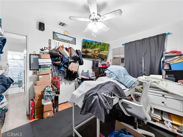 a bedroom with furniture and a fan