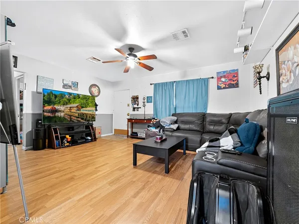 a living room with furniture a flat screen tv and kitchen view
