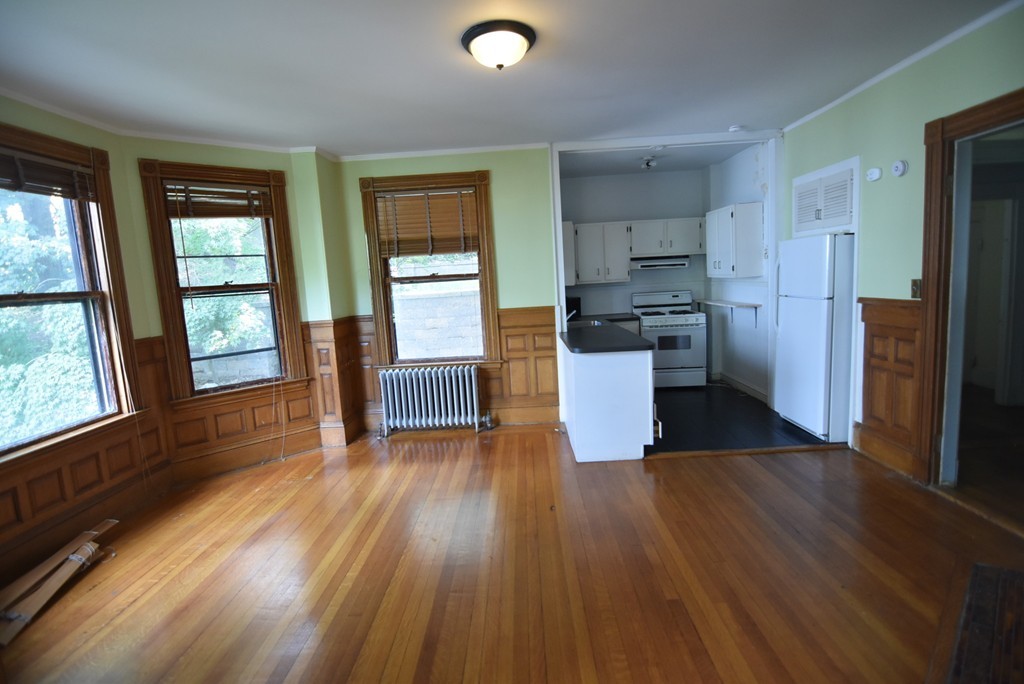 a kitchen with stainless steel appliances wooden floor and large window