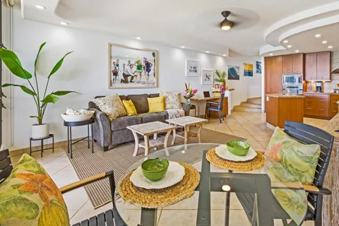 a living room with lots of furniture and a dining table with wooden floor