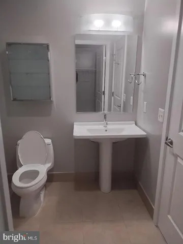 a bathroom with a sink toilet and mirror