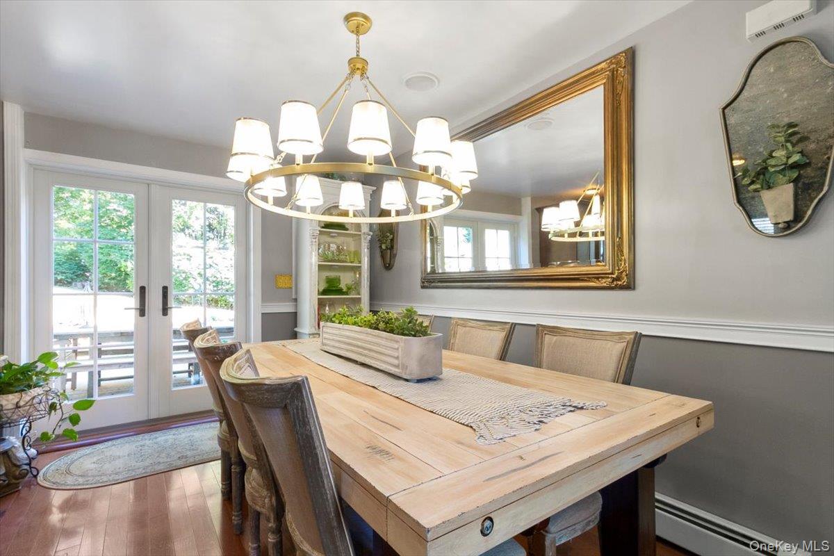 12 Philipse Road Carmel, NY 10512 - Photo 5 of 15 a dining room with wooden floor a chandelier a wooden table and chairs