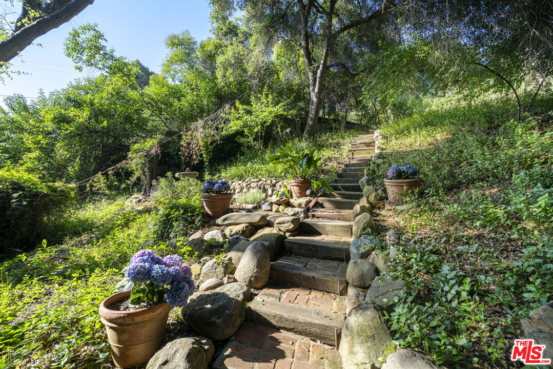 21658 Encina Road Topanga, CA 90290 - Photo 30 of 53 a view of a backyard filled with furniture and a garden