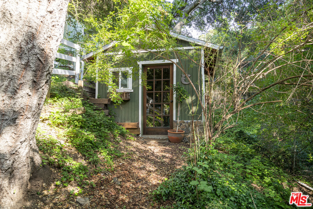 21658 Encina Road Topanga, CA 90290 - Photo 41 of 53 a view of a house with potted plants and large trees