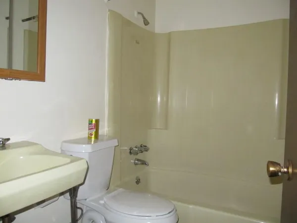 a white toilet sitting next to a bathroom sink and vanity