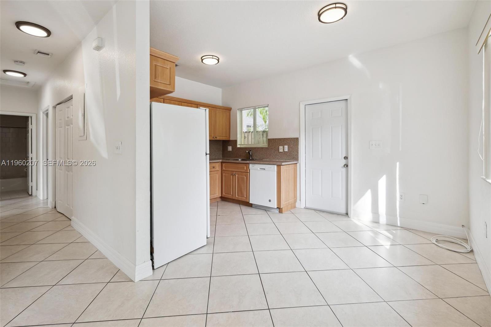 3134 Hibiscus Street Miami, FL 33133 - Photo 14 of 21 a kitchen with white cabinets and refrigerator