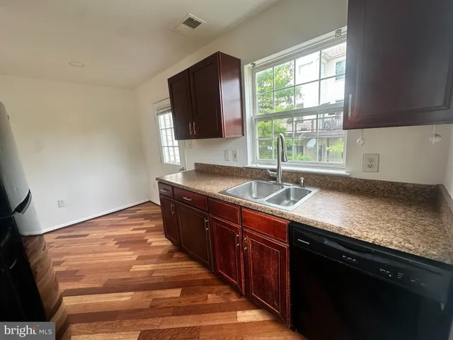 a view of a hallway with wooden floor and windows