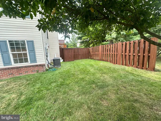 a view of a house with backyard and a tree