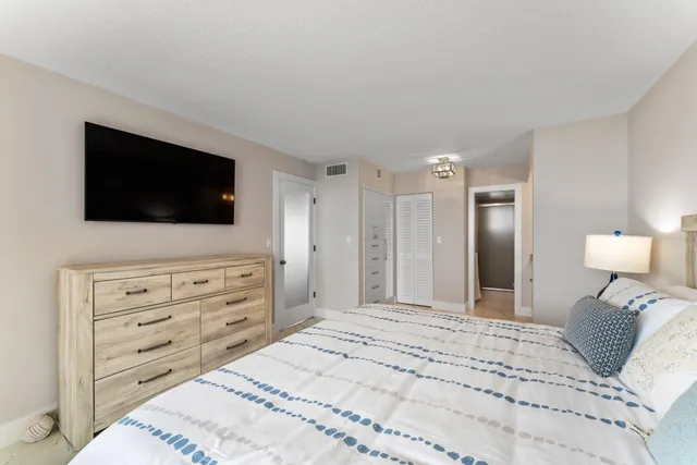 a bedroom with a bed a flat screen tv and a couch