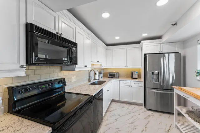 a kitchen with stainless steel appliances granite countertop a refrigerator sink and cabinets