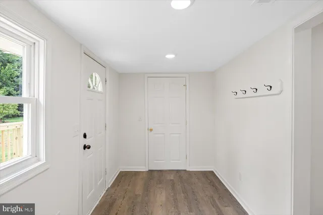 a view of a hallway with wooden floor and a window