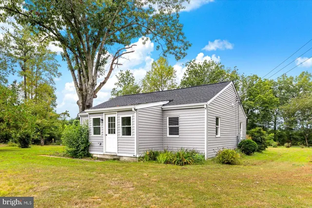 a white house that has a tree in front of it