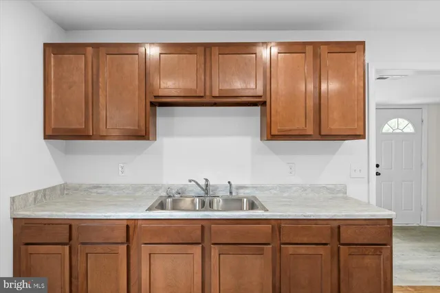 a kitchen with granite countertop white cabinets and sink
