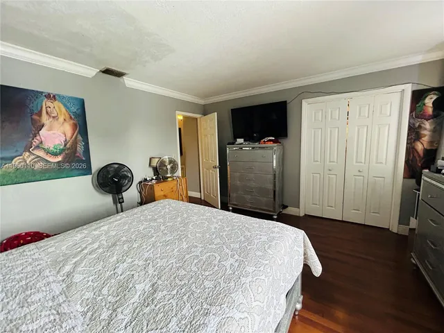 a bedroom with a bed tv and a window